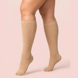 Woman wearing skin-tone beige Velora wide-fit knee-high compression socks
