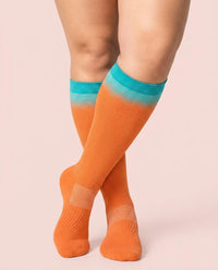 velora patterns wide fit compression socks gradient orange knee high women pose demure crossed